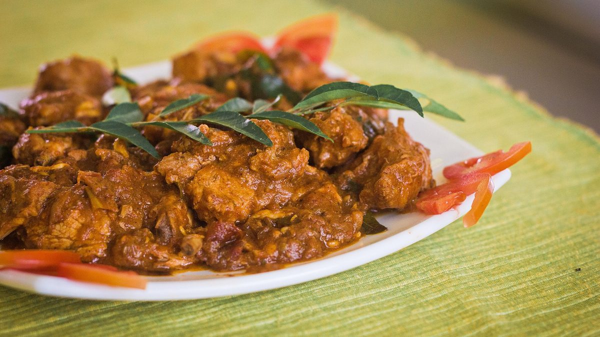 Plate mein Kerala style chicken curry, kadi patta aur tamatar ke saath